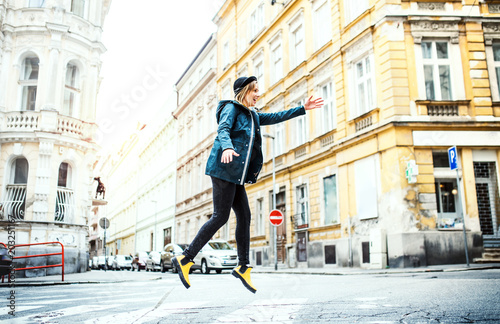 Fototapeta Naklejka Na Ścianę i Meble -  Young woman jumping on the street in town.