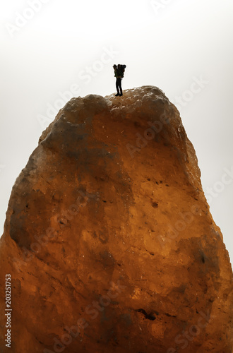 One traveler on the top of orange ice rock