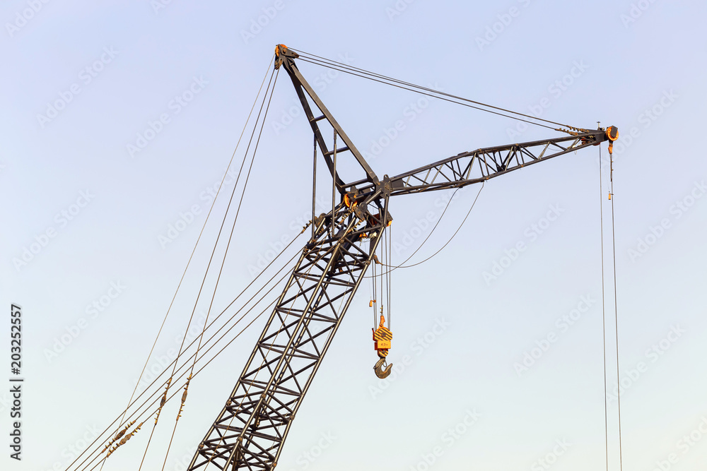 Heavy lifting crane on a construction site against a blue sky