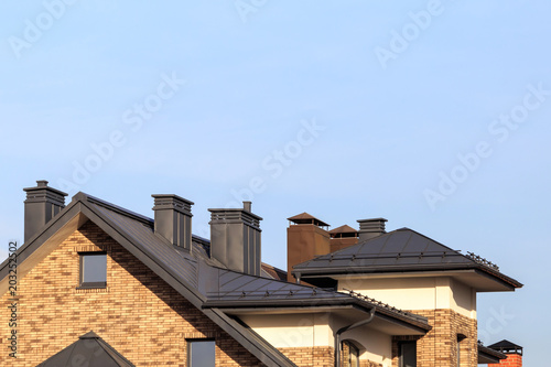 Roof from sheet metal with ventilation shafts and chimneys on a country cottage