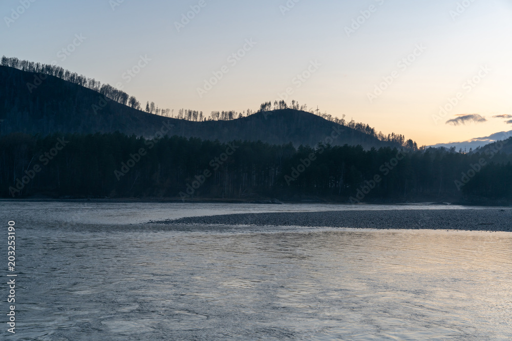 fog in mountains with forest and river on sunset background