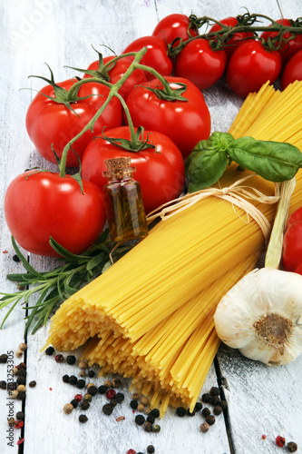 Italian food background with pasta, basil and tomato, health or vegetarian concept.