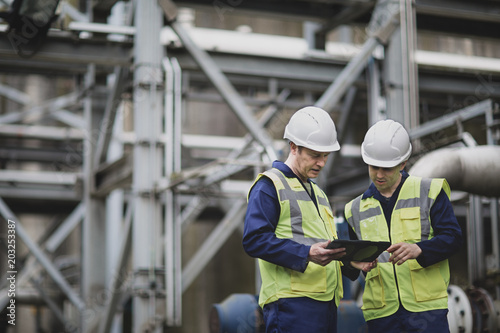 Industrial workers using a digital tablet on site photo