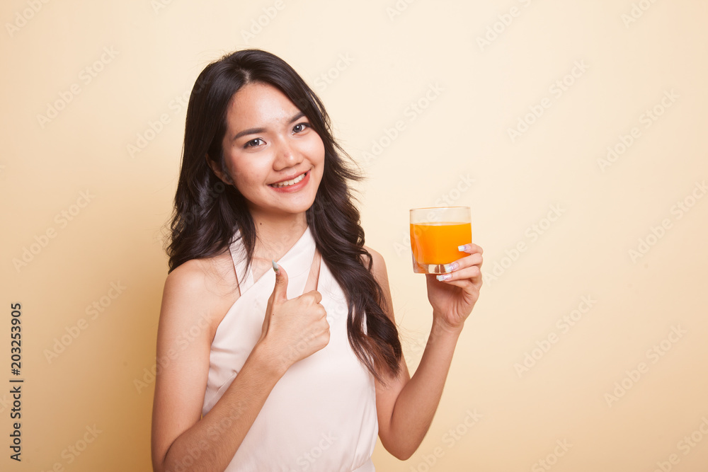 Young Asian woman thumbs up drink orange juice. Young Asian woman thumbs up drink orange juice.