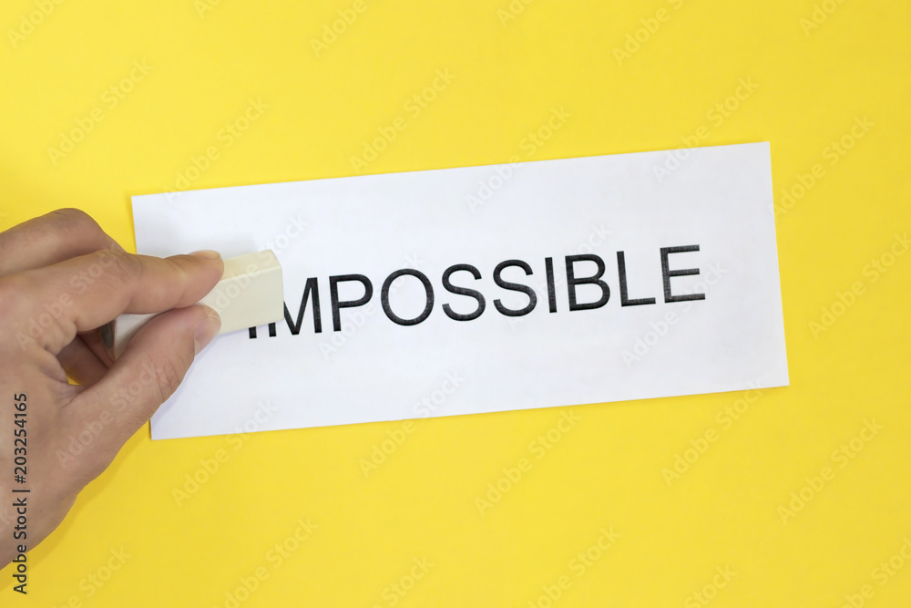 concept for self belief, positive attitude and motivation. Hand with eraser and corrected word impossible with possible.