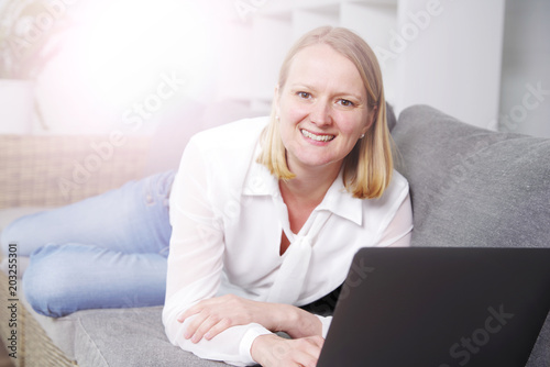 Frau mit Laptop auf der Couch 
