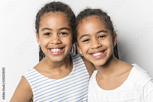 Adorable african twin little girls on studio gray background
