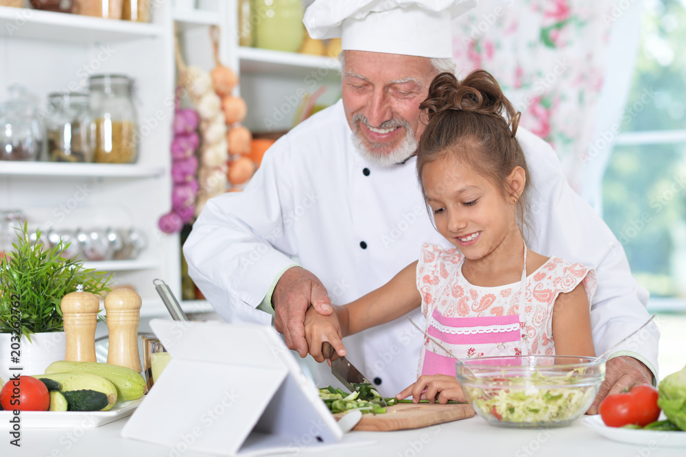man preparing dinner with granddaughter man preparing dinner with granddaughter