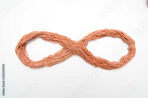 Yarn rope shaped as an infinity sign, isolated on white background