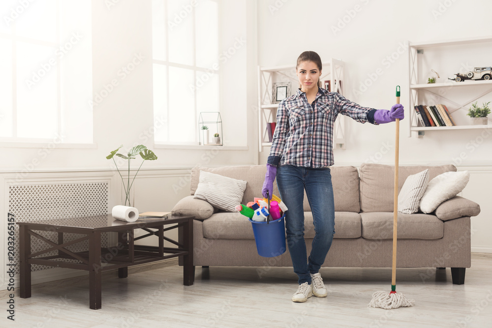 Woman with cleaning equipment ready to clean room