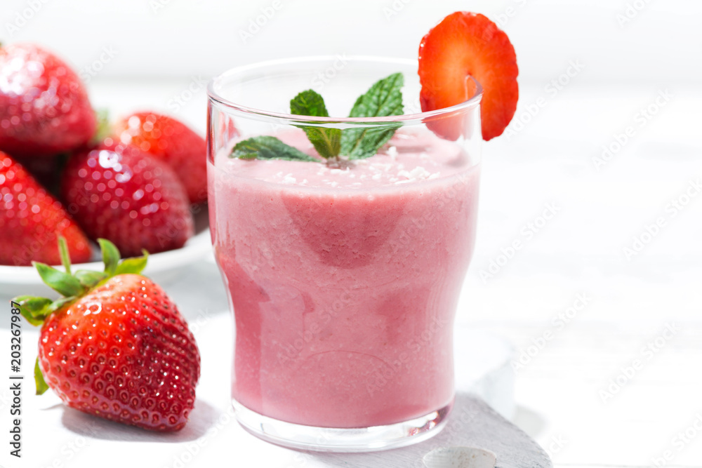 refreshing strawberry milkshake on white table, closeup refreshing strawberry milkshake on white table, closeup