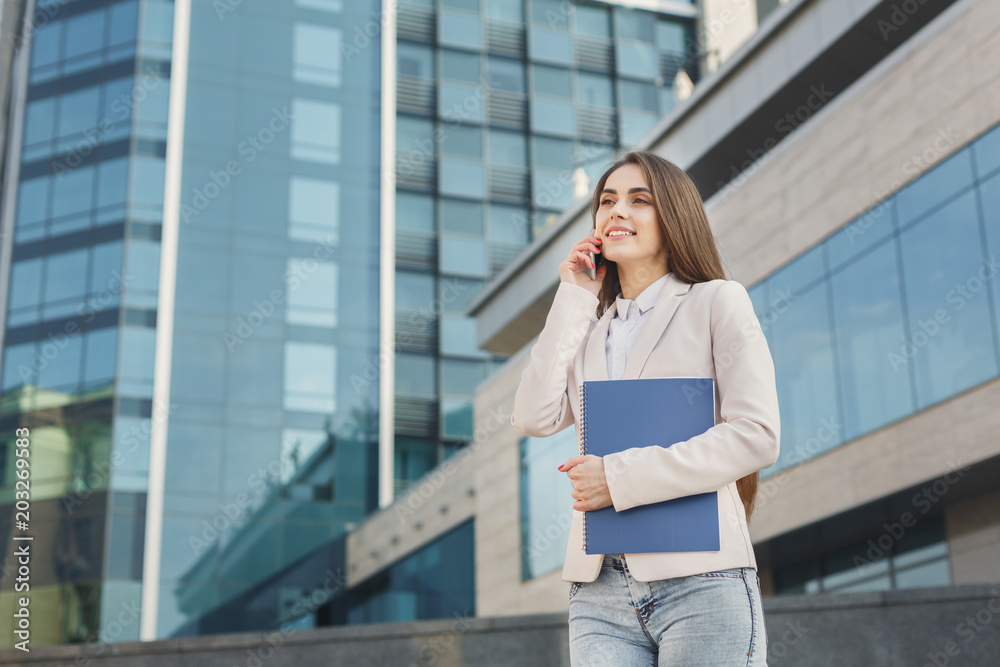 Fototapeta premium Confident young businesswoman talking on mobile