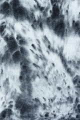 splashes black liquid color dye on cotton fabric abstract background.