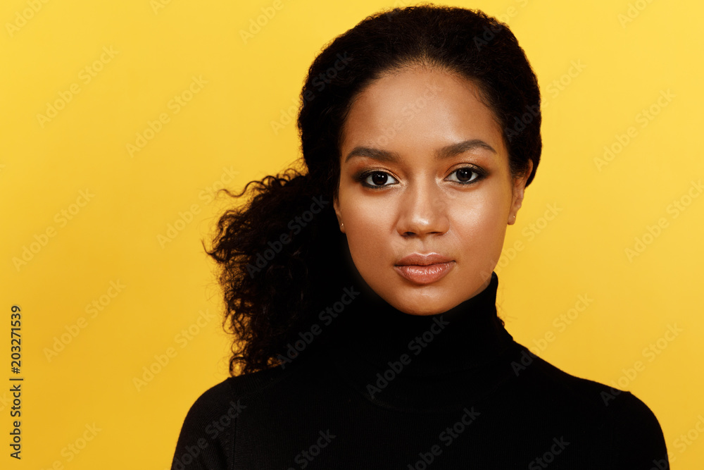 Portrait of a serious woman over yellow background - obrazy, fototapety, plakaty 
