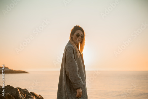 Portrait of woman wearing sunglasses and winter coat looking at camera smiling, side view, Odessa, Odeska Oblast, Ukraine, Eastern Europe photo