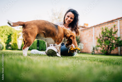 Photography Beautiful smiling woman and her dog in the backyard.