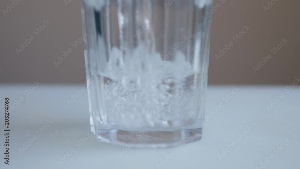 A slice of lemon falling into a glass of water A slice of lemon falling into a glass of water