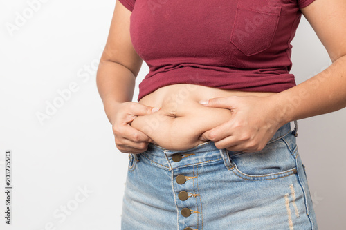 Overweight woman hand pinching excessive belly fat on gray background, Healthy concept