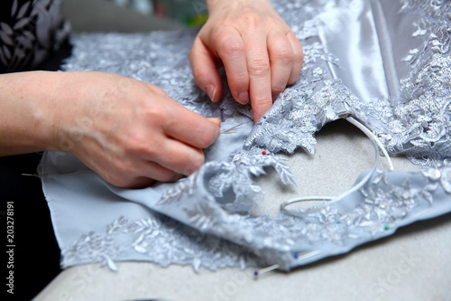 A woman embroidering a handmade dress. Today, tailoring can be called as an artistic profession. 