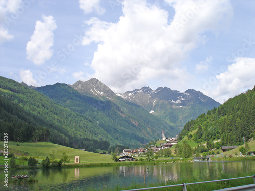 Bergdorf in Südtirol, Italien/ein Bergdorf mit einem kleinen Teich umgeben von den Südtiroler Bergen
