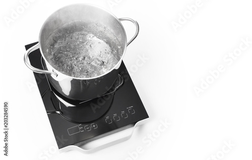 Portable induction cooktop and frying pan on white background