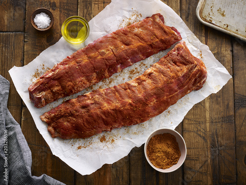 Overhead view of raw ribs with dry rub on baking paper