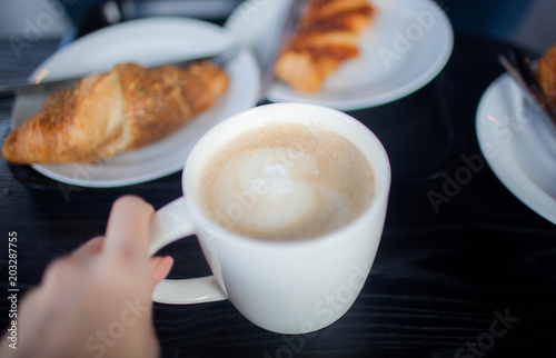 Cup of double espresso coffee with piece of cake on wooden table photo