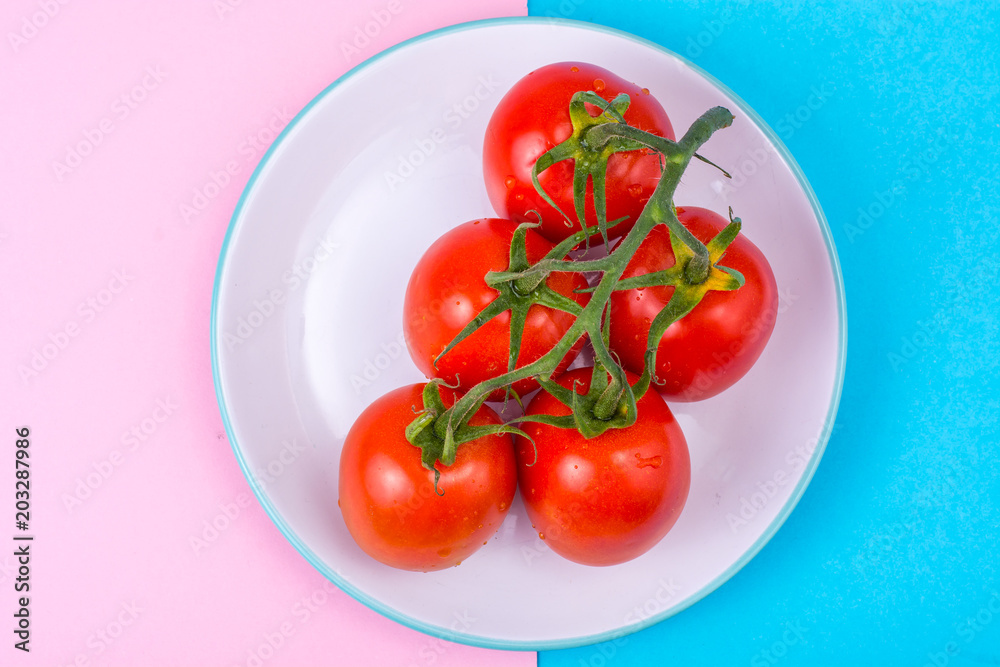 Branch of red tomatoes on bright background Branch of red tomatoes on bright background