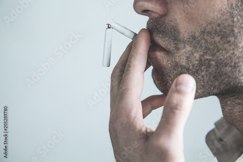 Caucasian man smoking broken cigarette. Stop smoking
