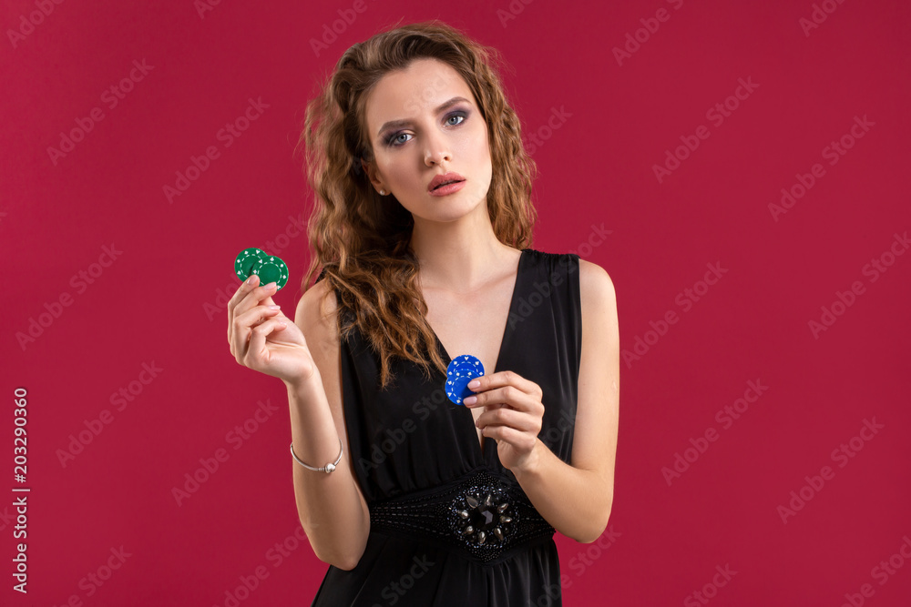 Pretty long hair woman holding chips for gambling. Studio shot