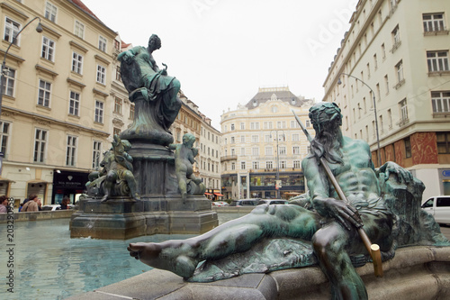 Canvas Print Vienna, Austria - 15 April 2018: People sit on the steps near the fountain monument