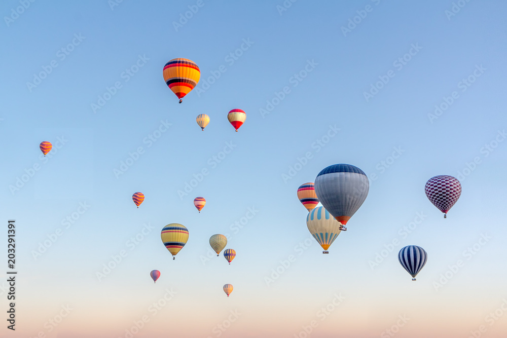 Obraz premium Bright multi-colored hot air balloons flying in sunsrise sky Cappadocia