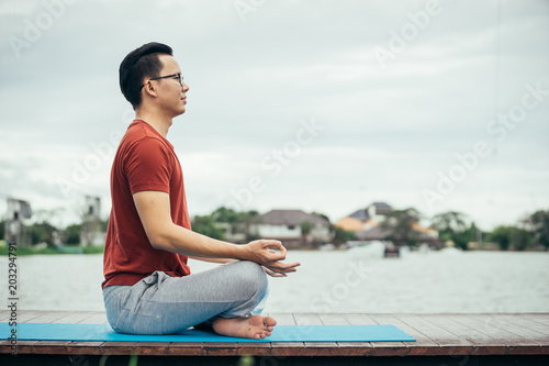 Asian man playing with a yoga school at yoga class in early morning. Lifestyle and healty concept.