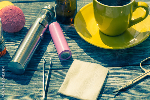 Still life with e-cig and jiuce on the wooden background photo