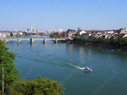 Cityscape landscape of swiss european Basel city and Middle bridge over Rhine River with motorboat in Switzerland photo