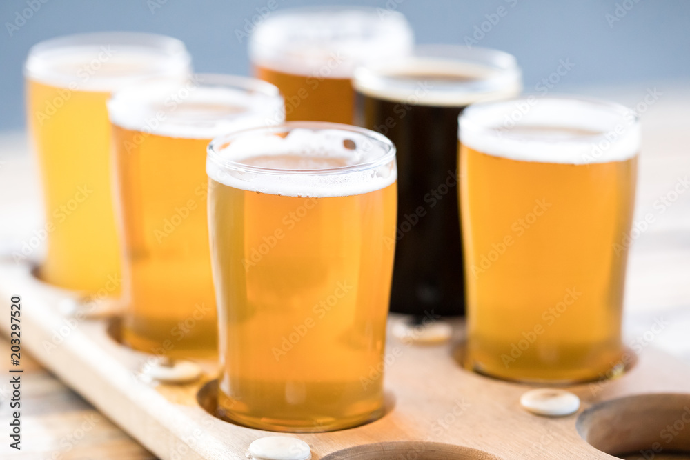 Flight of craft beer in pint glasses on a wood tray