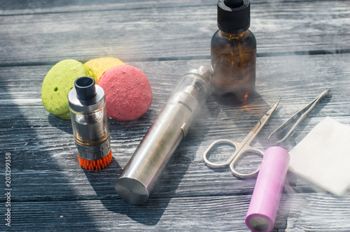 Still life with e-cig and jiuce on the wooden background photo