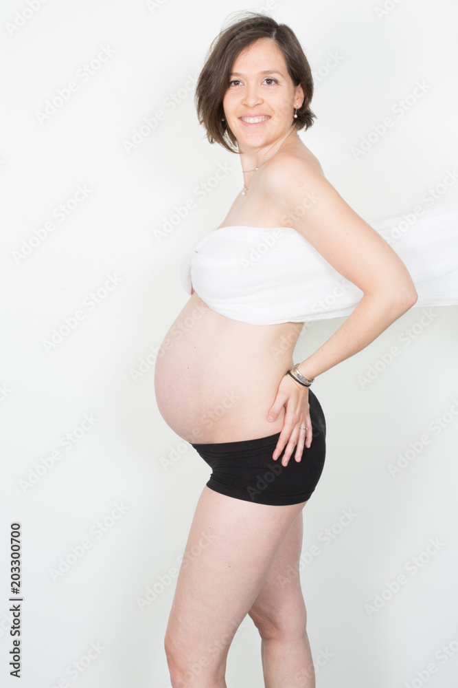 Beautiful young pregnant girl in studio shot on white background Beautiful young pregnant girl in studio shot on white background