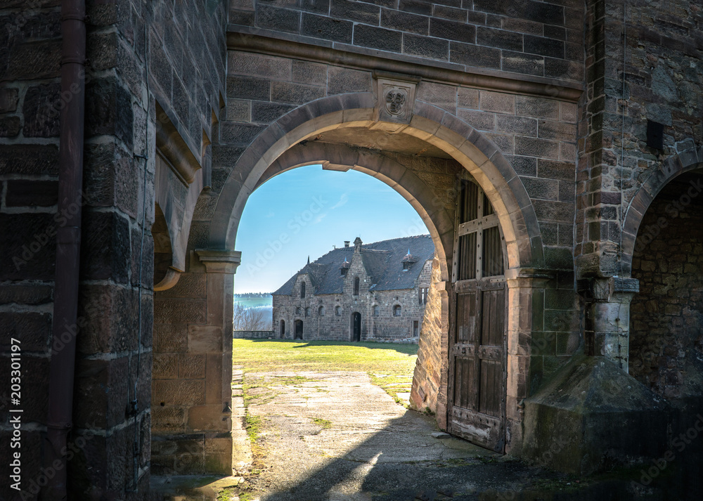 Naklejka premium Crooked castle gate allowing a view inside the premises