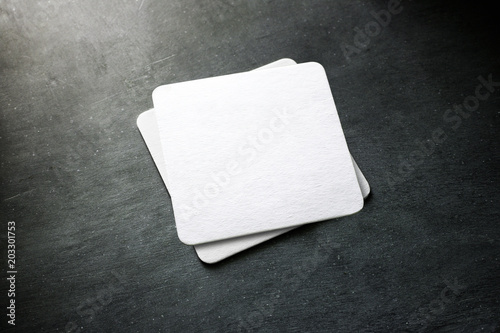 Blank white beer coaster stack mockup, top view, lying on the textured background. Squared clear can mat design mock up isolated. Quadrate cup rug display