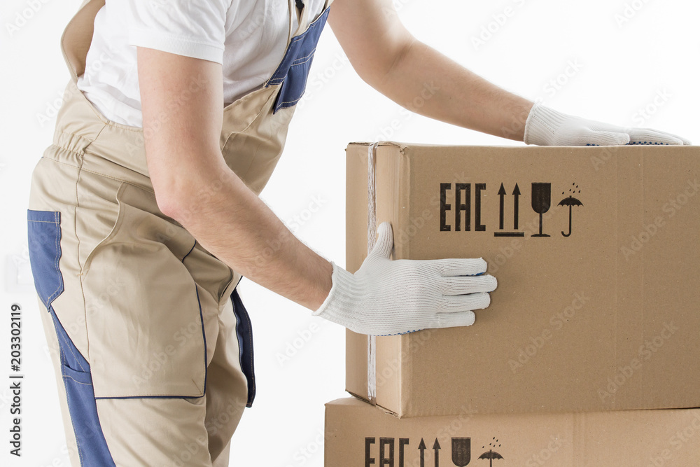 relocation services concept. Mover's hands In uniform carrying cardboard Box. Loader puts cardboard boxes isolated on white background. Worker mover unloading paper box. Delivery man