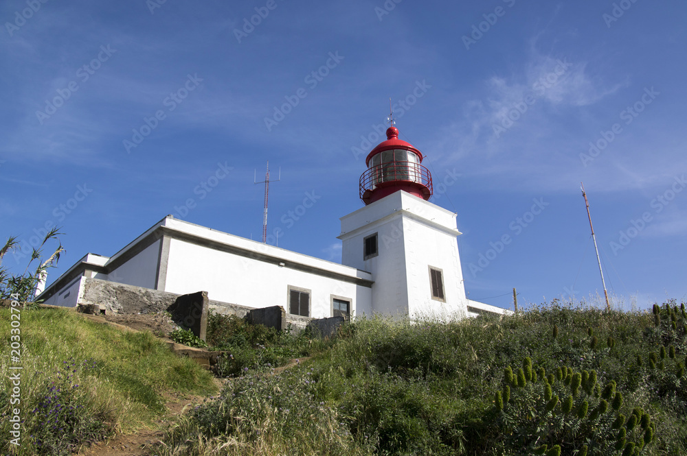 White romantic lighthouse on the cliff, west Madeira island, village Ponta do Pargo, Portugal, Atlantic ocean White romantic lighthouse on the cliff, west Madeira island, village Ponta do Pargo, Portugal, Atlantic ocean