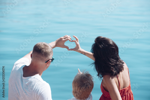Love and trust as family values. Family travel with kid on mothers or fathers day. Summer vacation of happy family. Child with father and mother. Mother and father with son at sea beach