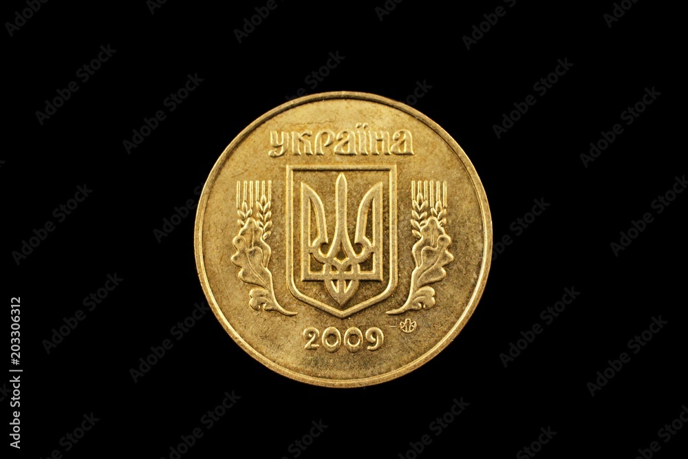 A macro image of a Ukrainian fifty kopiyka coin isolated on a black background A macro image of a Ukrainian fifty kopiyka coin isolated on a black background