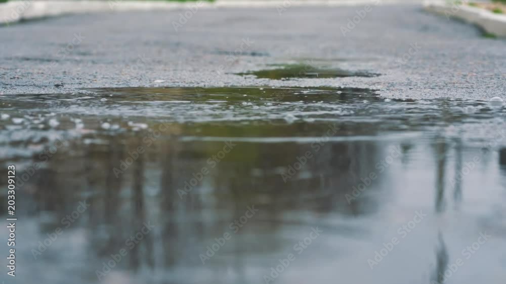 Close up shot of legs of a runner in sneakers. Female sports man jogging outdoors in a park, stepping into muddy puddle. Close up shot of legs of a runner in sneakers. Female sports man jogging outdoors in a park, stepping into muddy puddle.