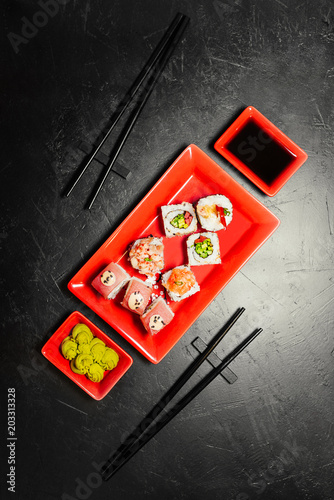 Set of sushi, Japanese knife, chopsticks and on dark stone table. Top view with copy space. Wasabi, soy sauce. Sushi on a table.