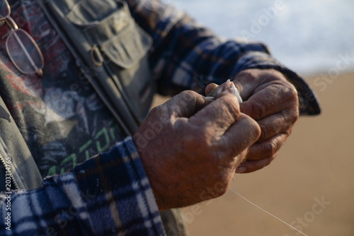 Hand holding a fish caught on a fishing line in lake. © aquar