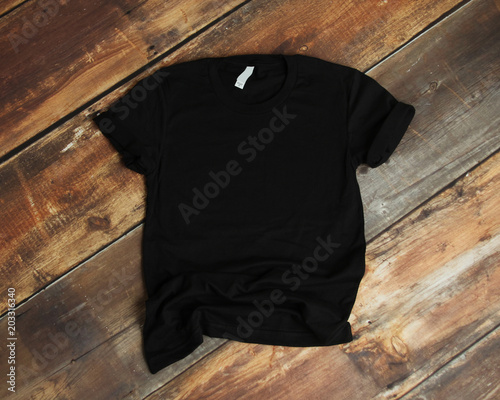 Mockup of blank black tshirt on rustic wood background