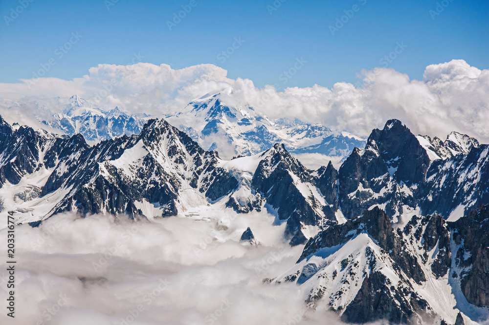 Naklejka premium Close-up of snowy peaks and mountains, viewed from the Aiguille du Midi, near Chamonix. A famous ski resort located in Haute-Savoie Province, at the foot of Mont Blanc in the French Alps.