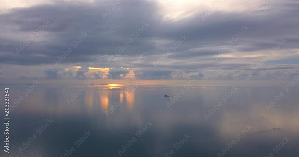 Over the calm sea with pastel sunset skies. Very low altitude over the water into the the horizon line Over the calm sea with pastel sunset skies. Very low altitude over the water into the the horizon line